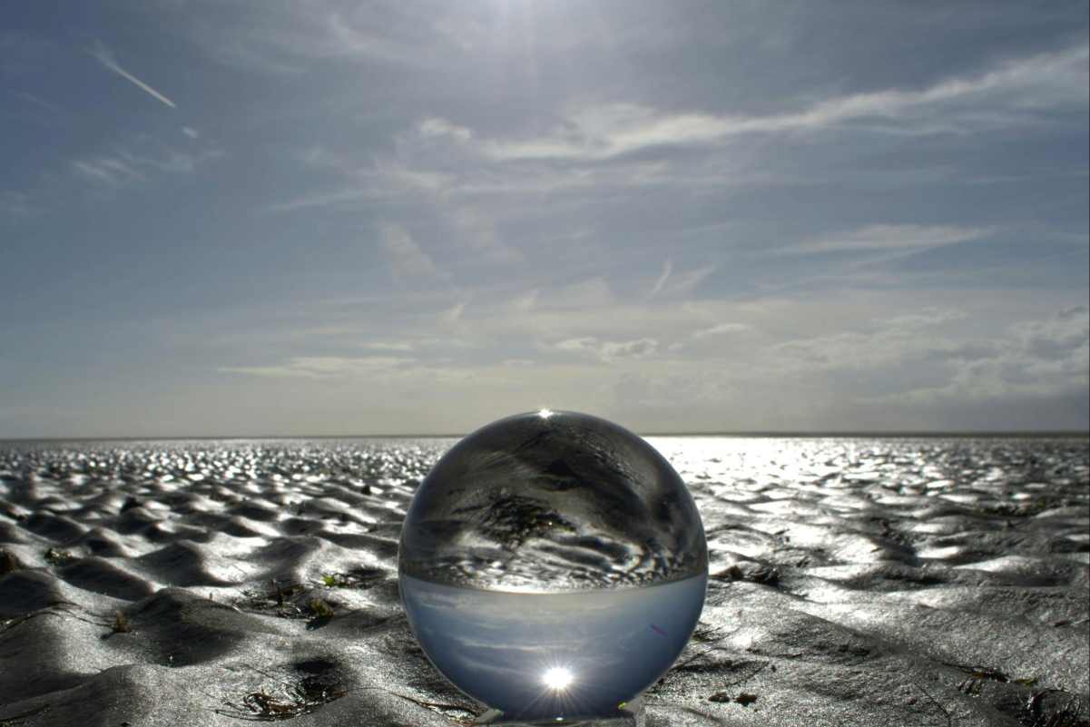 Crystal ball on reflective sand symbolizing new perspectives, balance, and clarity in therapy approaches