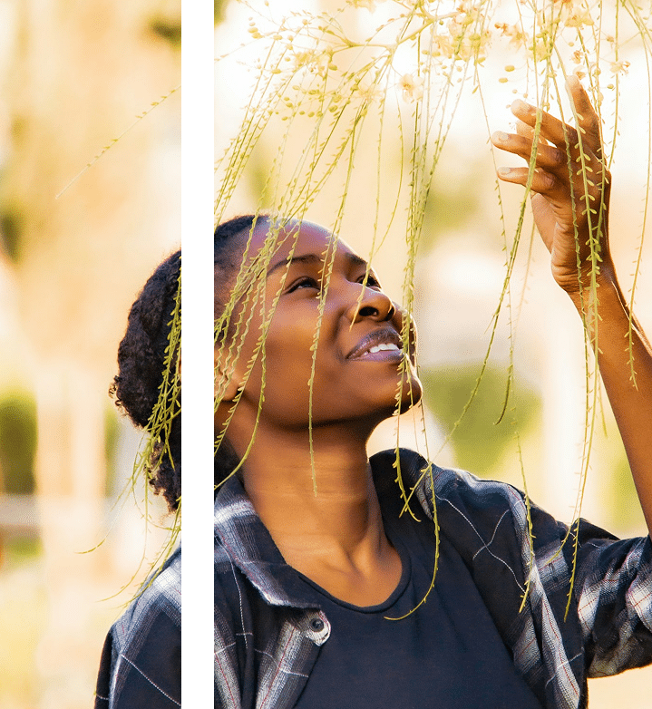 a woman holding a bunch of plants up to her face