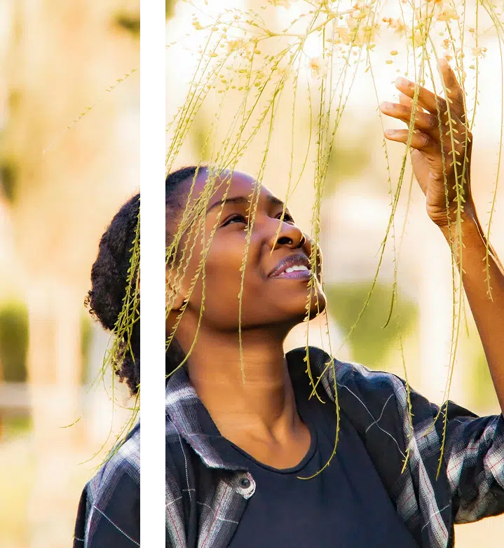 a woman holding a bunch of plants up to her face