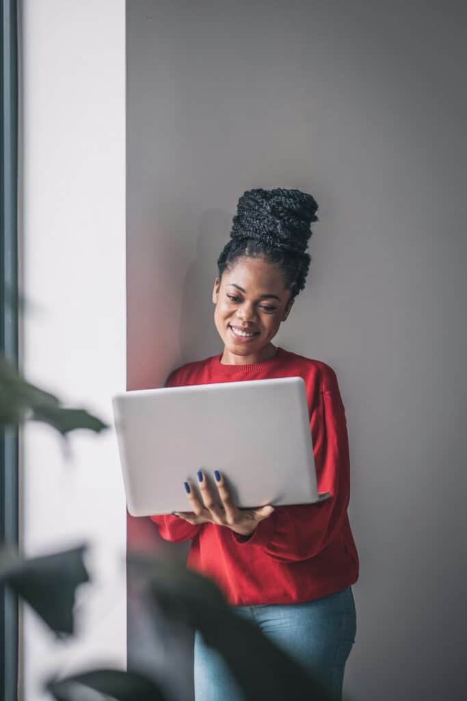 Smiling Black woman with natural hair on laptop attending virtual OCD therapy session with Atlanta therapists in Georgia