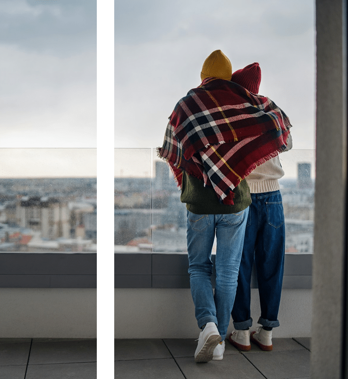 Intimate couple embracing by skyscraper window with city view strengthening relationship through DBT therapy in Atlanta GA