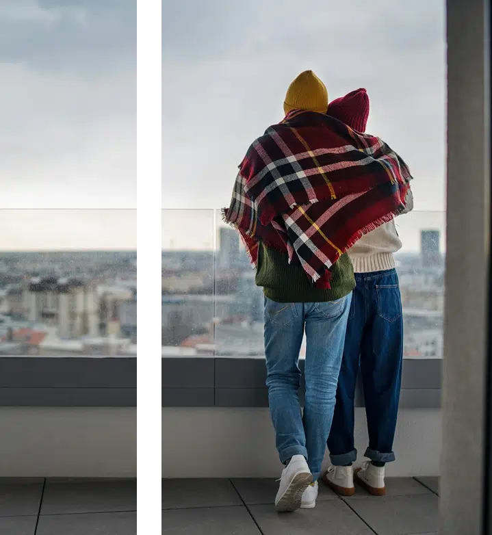 Intimate couple embracing by skyscraper window with city view strengthening relationship through DBT therapy in Atlanta GA
