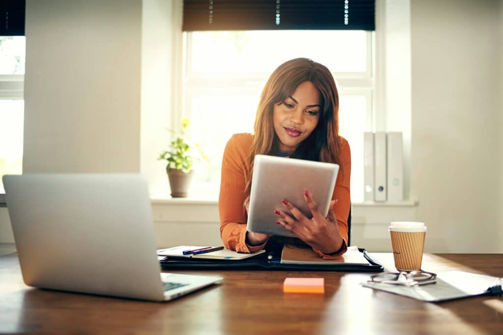 Woman using tablet at kitchen counter managing daily life without checking compulsions after OCD therapy in Atlanta Georgia