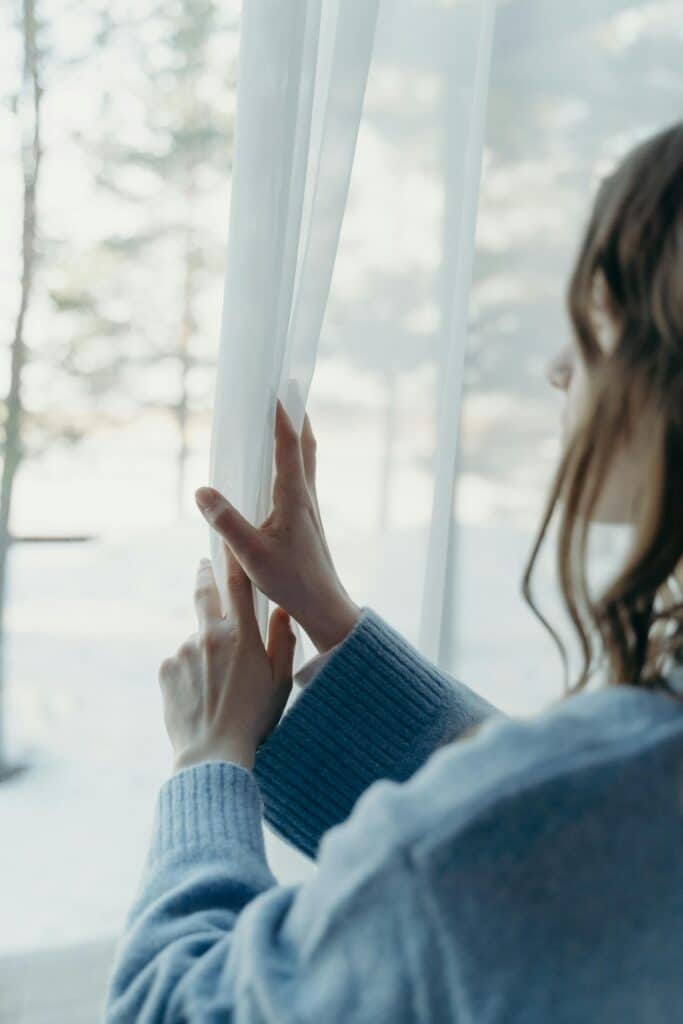 Woman looking thoughtfully out window before starting exposure response prevention therapy for OCD in Atlanta Georgia area