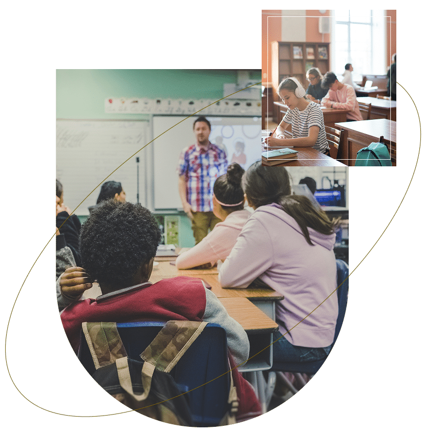 Students at desks in a classroom with a teacher at the front.
