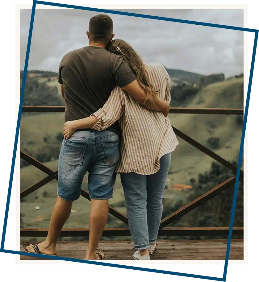 Two hands gently holding each other with a tree in the background