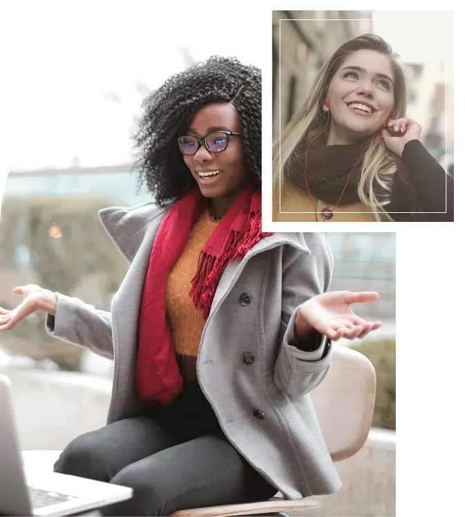 Two women smiling while talking, one on a laptop and the other walking on a phone call