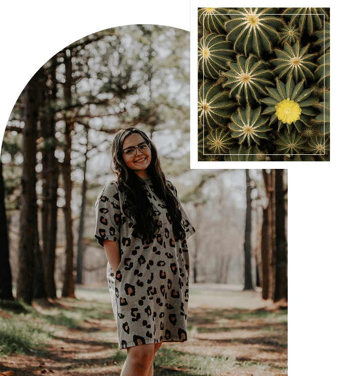 A woman standing in a forest, smiling gently among tall trees and soft natural light