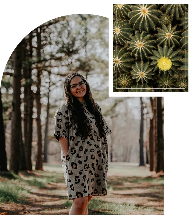 A woman standing in a forest, smiling gently among tall trees and soft natural light