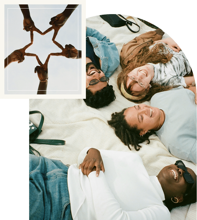 Group lying close together, laughing and sharing a moment of lightness and connection with hands joined together in a star shape, representing unity, support, and shared healing