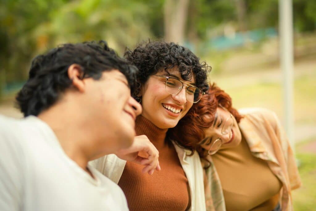 Group of people leaning on each other, smiling and relaxed, showing trust and emotional connection