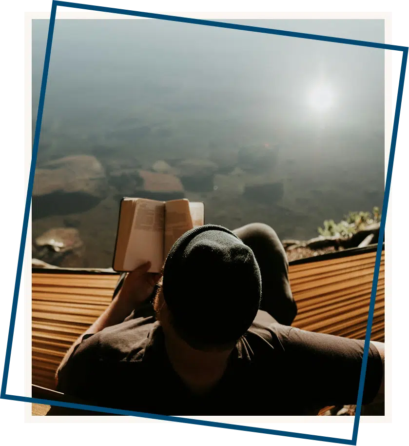  A man reading a book beside a scenic nighttime view