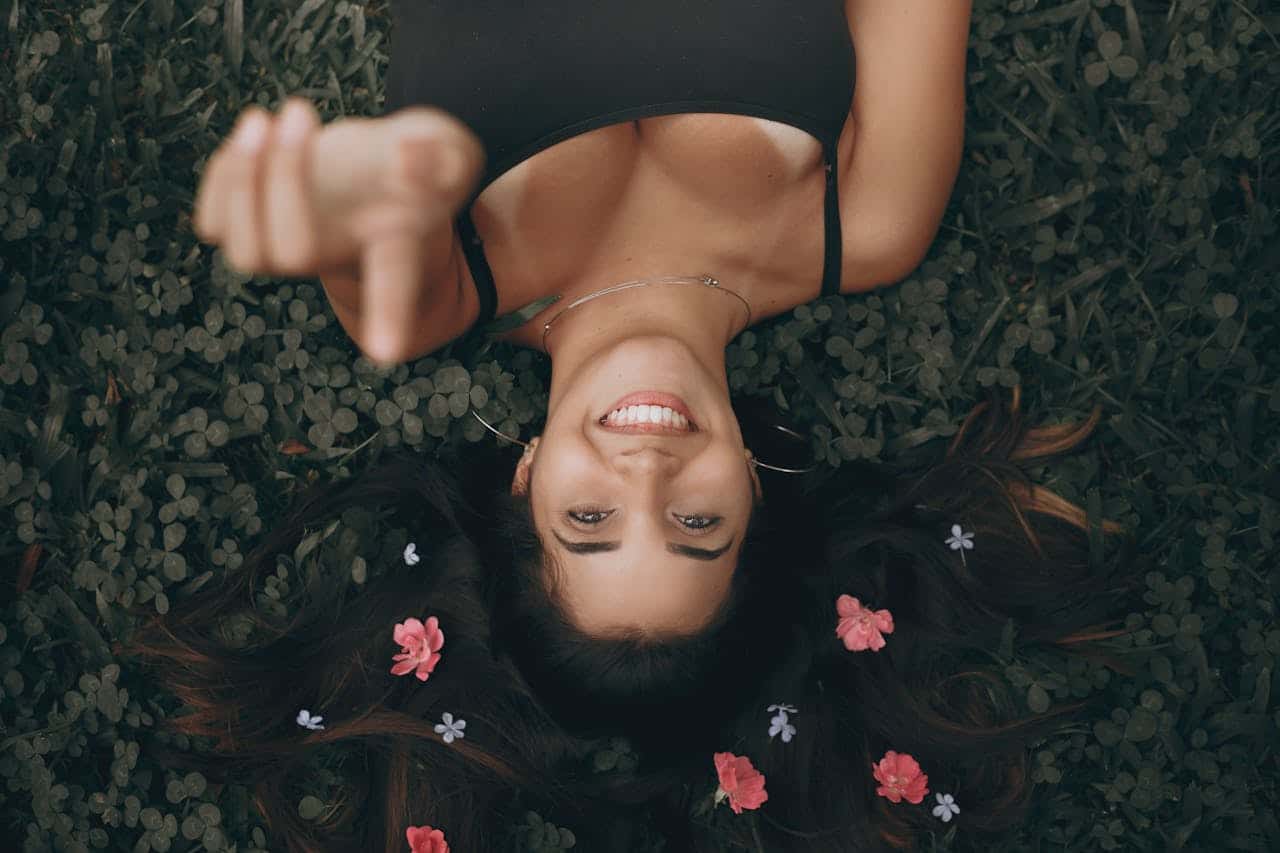 Woman lying on grass with flowers, symbolizing emotional regulation and healing through DBT for trauma