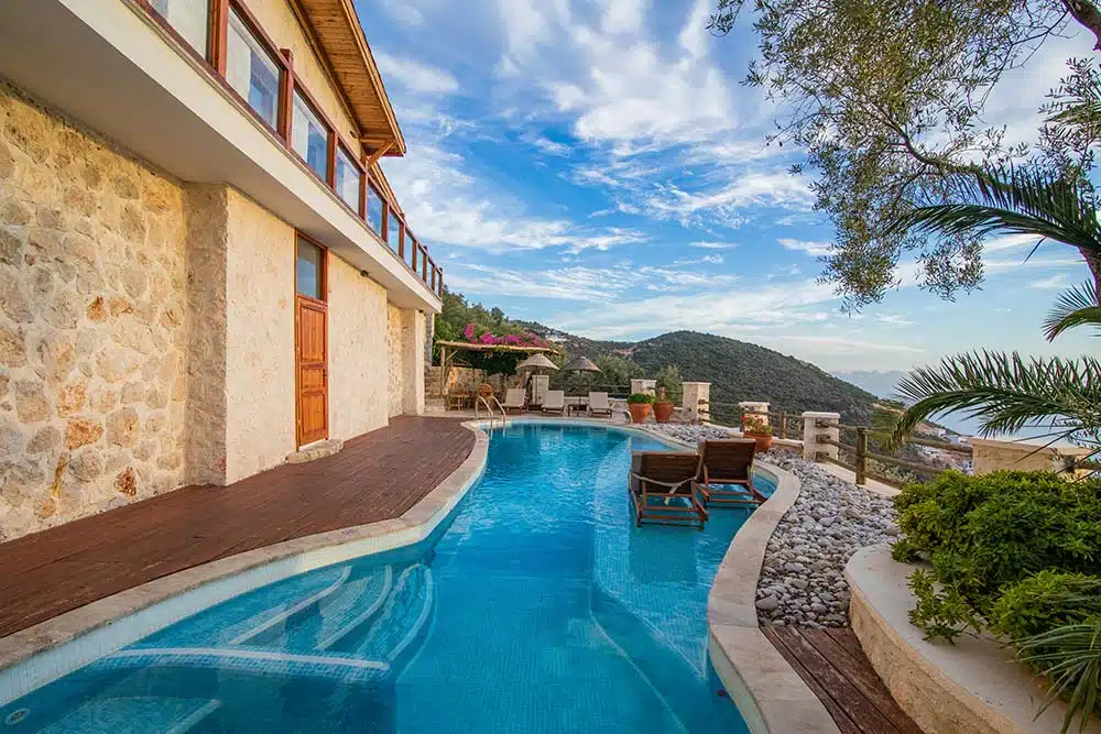 A large swimming pool next to a stone building 