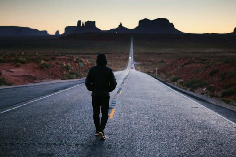Man walking in the center of a road