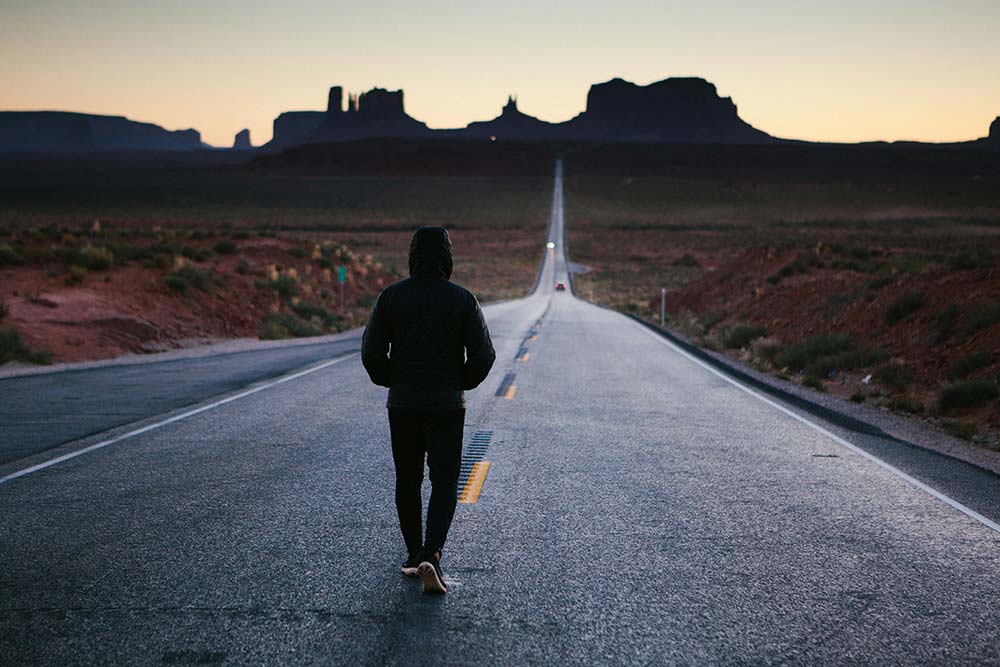 Man walking in the center of a road