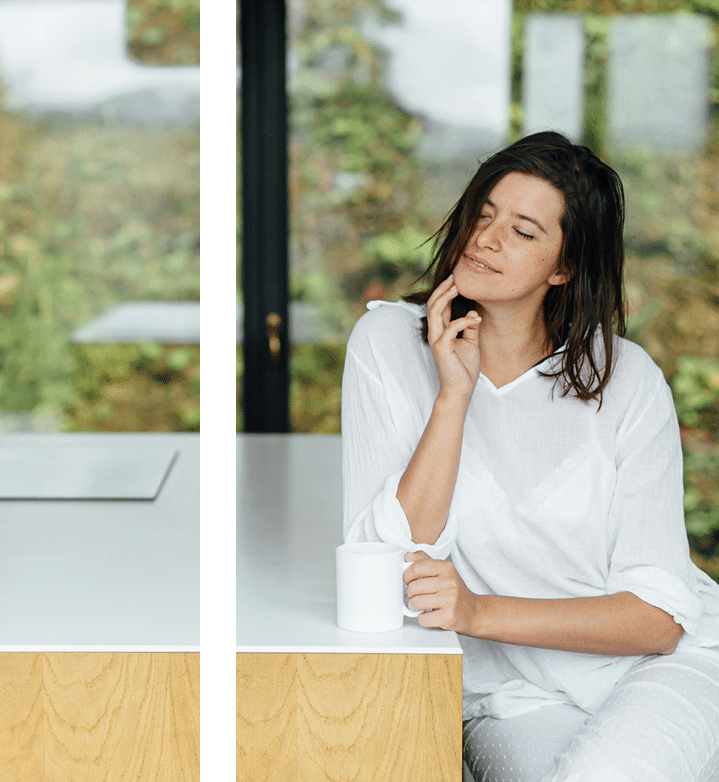 A beautiful happy woman enjoying hot coffee in the kitchen
