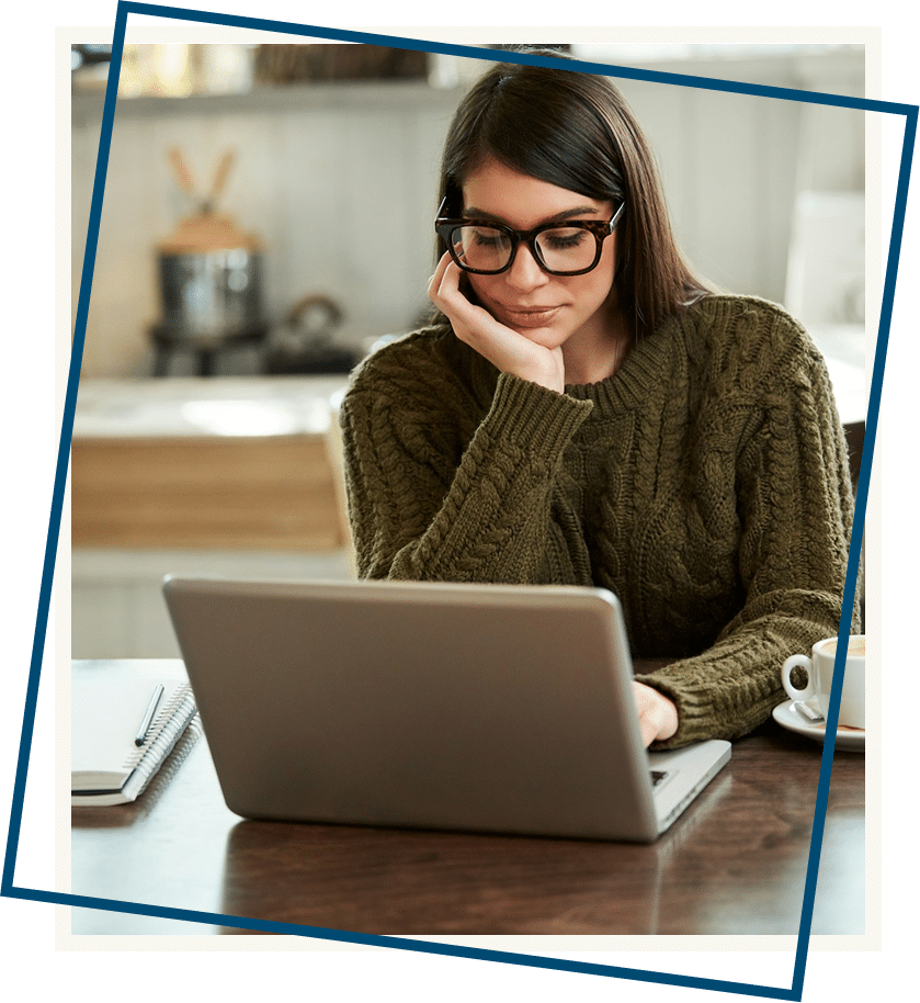 A caucasian brunette in sweater sitting in cafe and using laptop