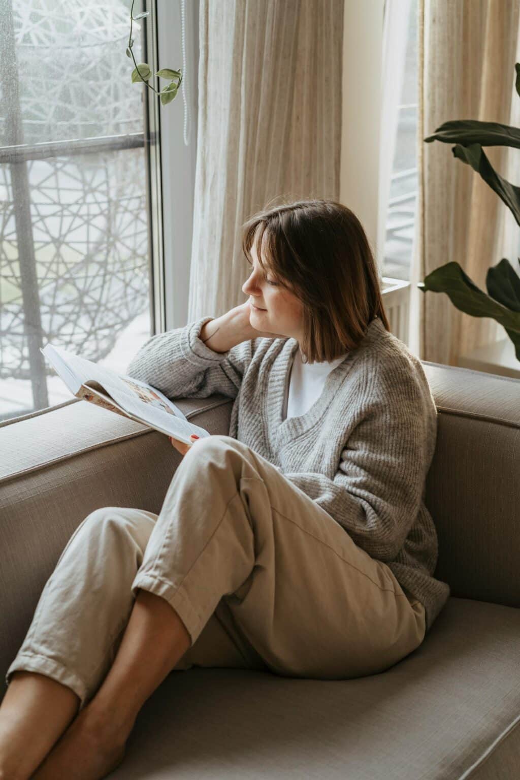 A woman reading a book on a couch