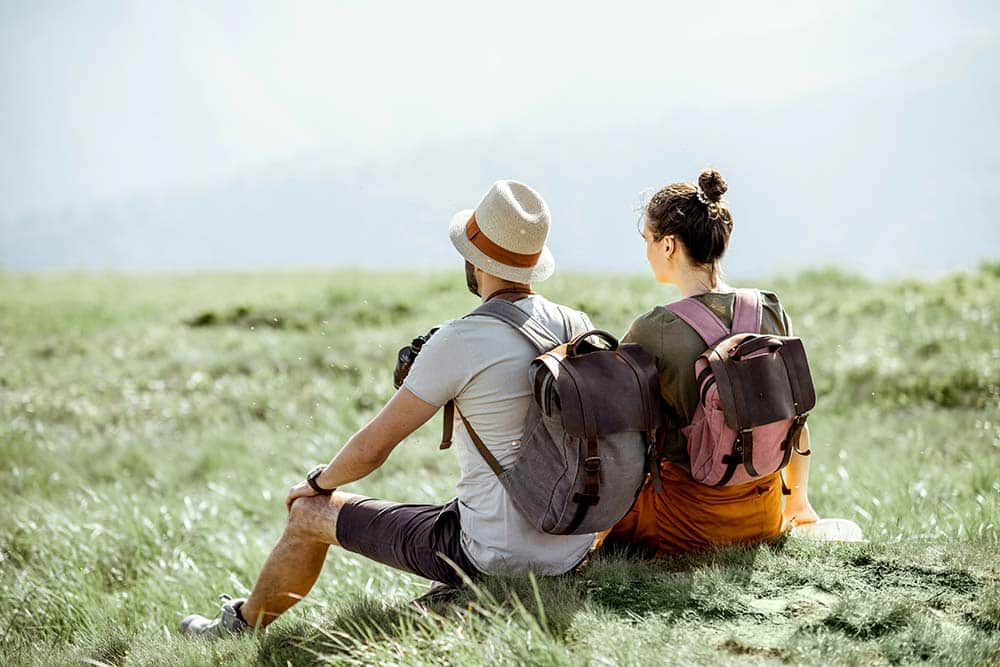 young couple sitting on the green meadow